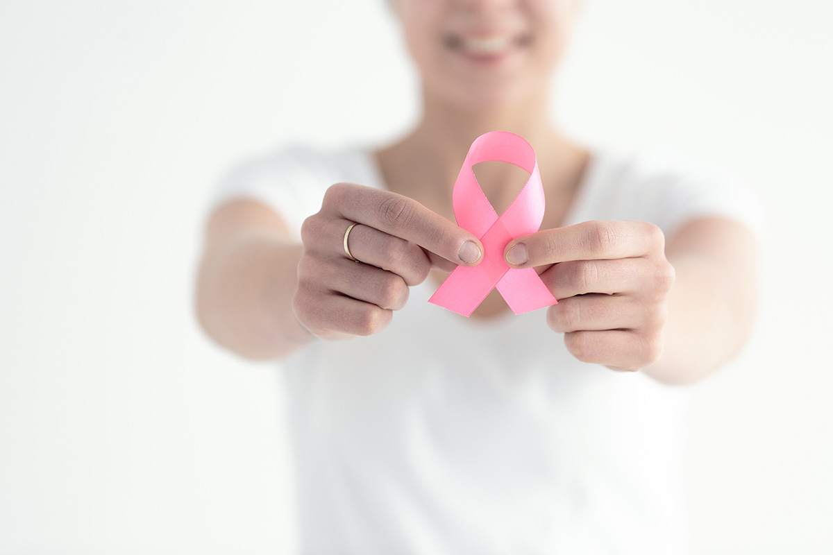 Woman holding pink breast cancer ribbon